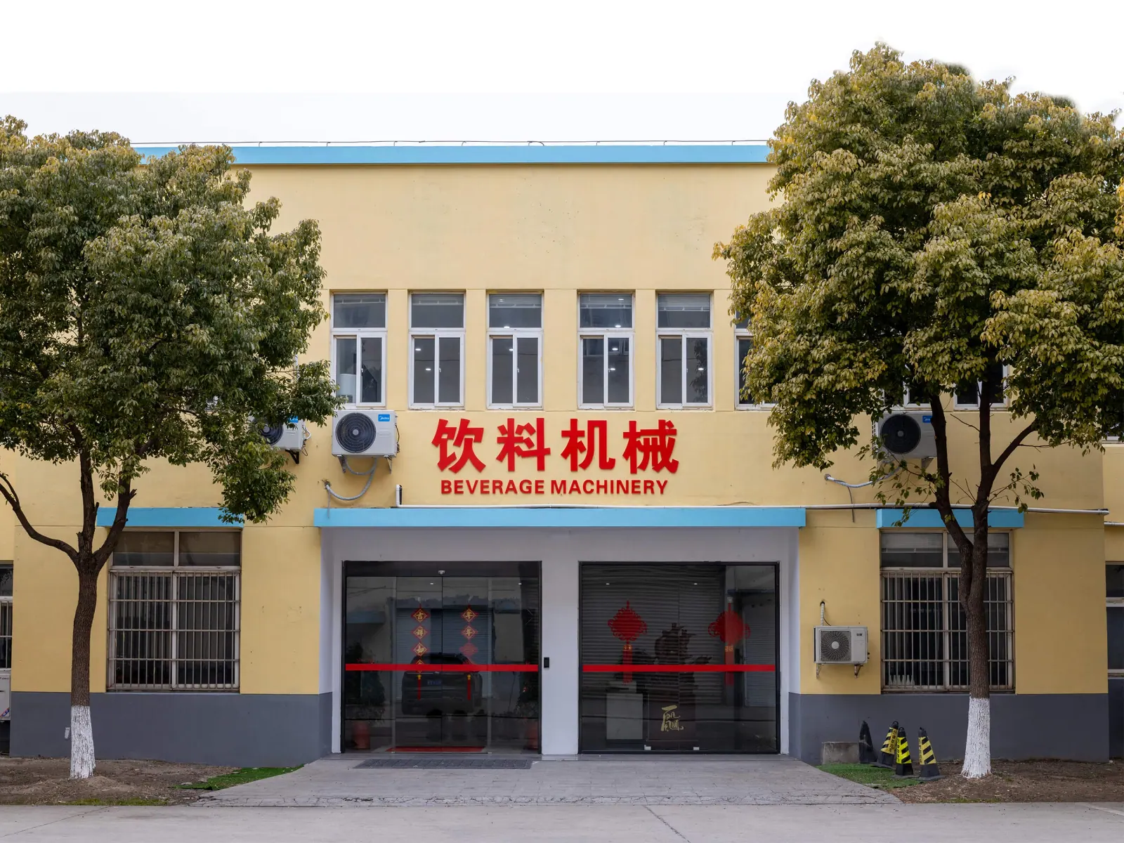 Factory entrance with the red 饮料机械 and BEVERAGE MACHINERY signs