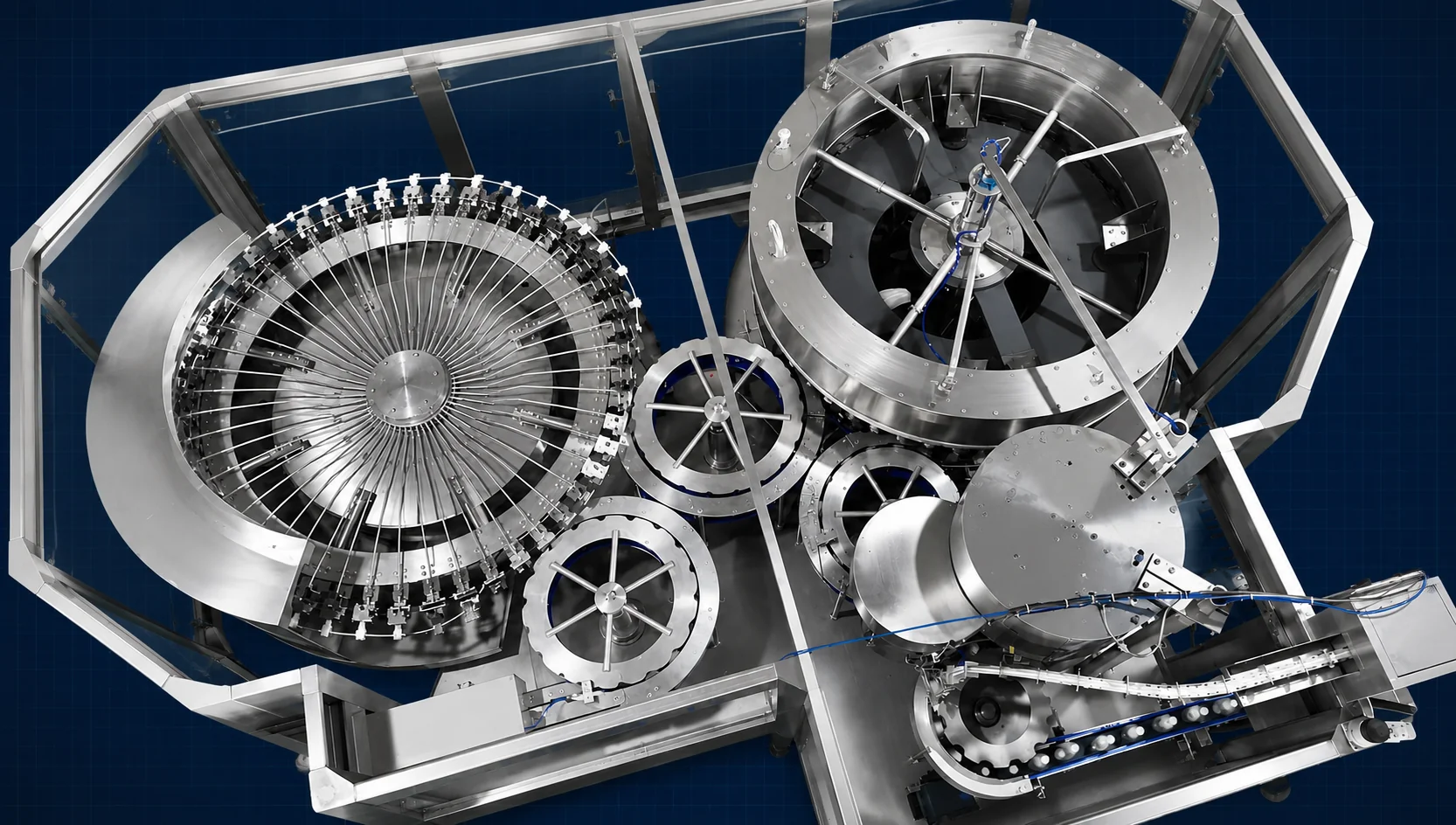 Top-down view of rotary filling and capping machine with star wheel infeed, Planet Machinery