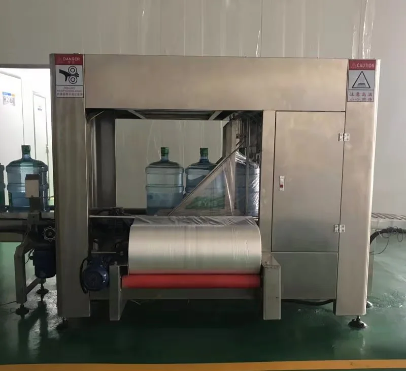 Automatic machine applying a protective plastic bag to finished five-gallon water bottles
