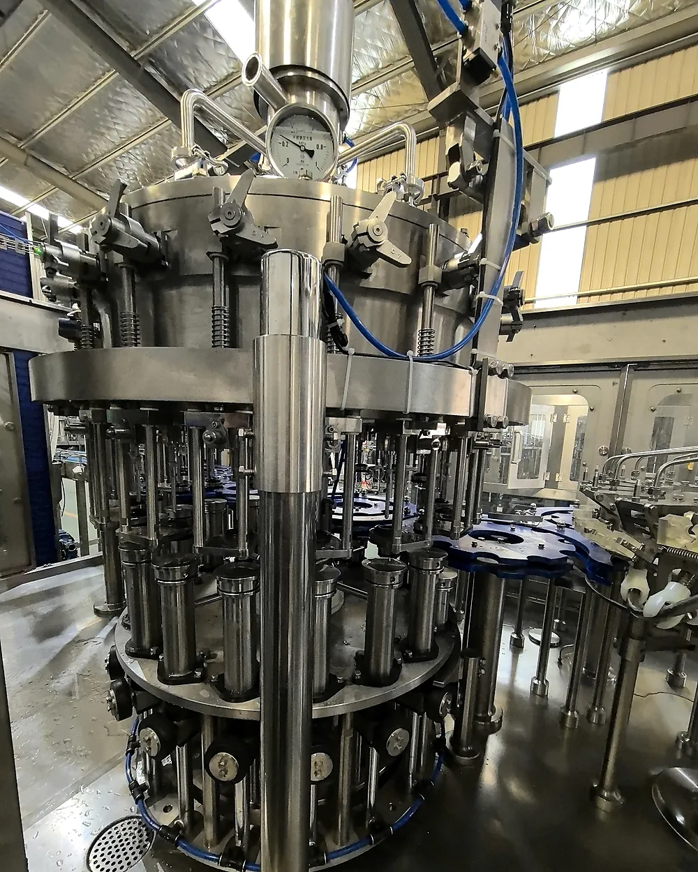 Close view of the stainless-steel counter-pressure filling valve assembly for glass bottles