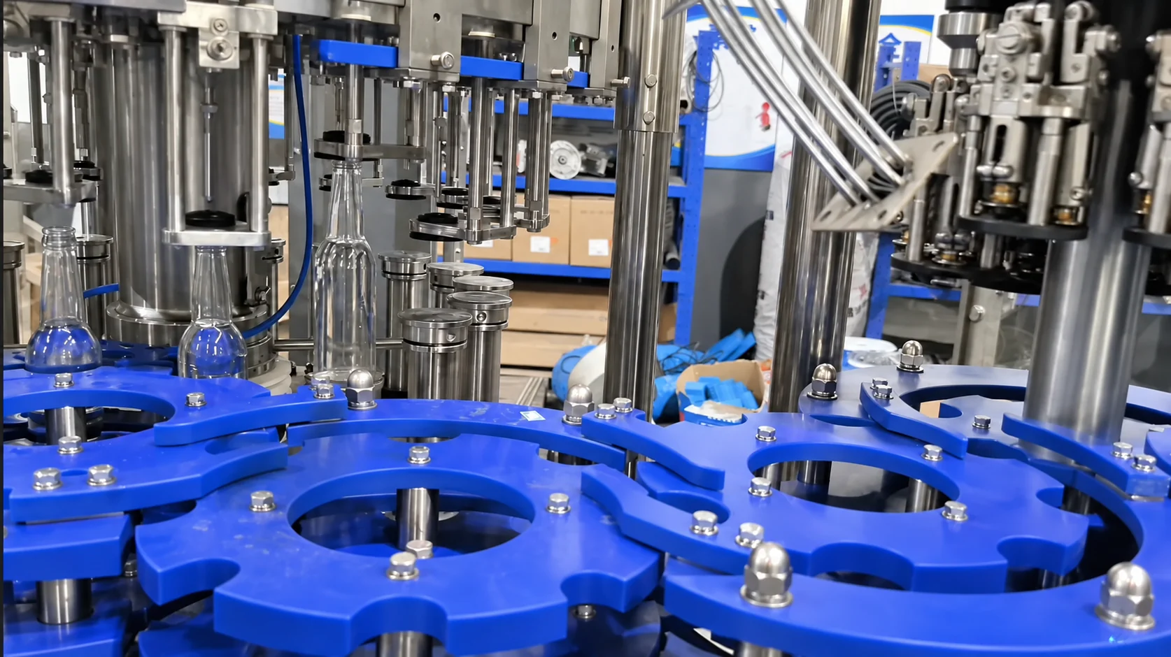 Glass bottles moving through an automatic rotary filling and closing station