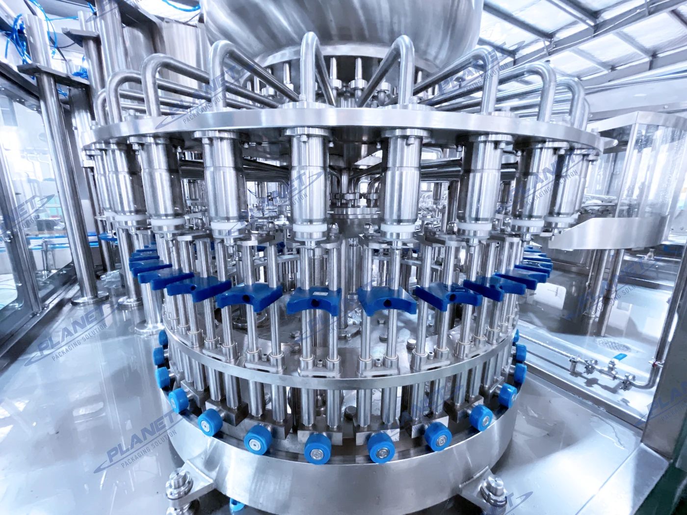 PLANET hot-fill valve carousel inside a stainless-steel filling machine