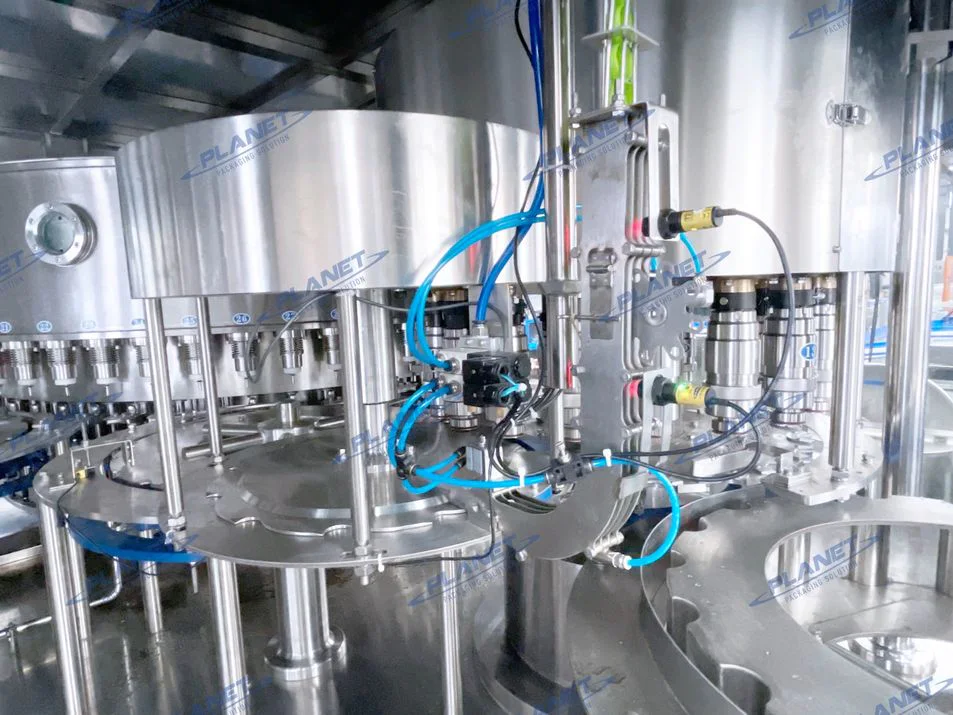 Inside the PET water filler showing the automatic bottle capping station and cap handling components