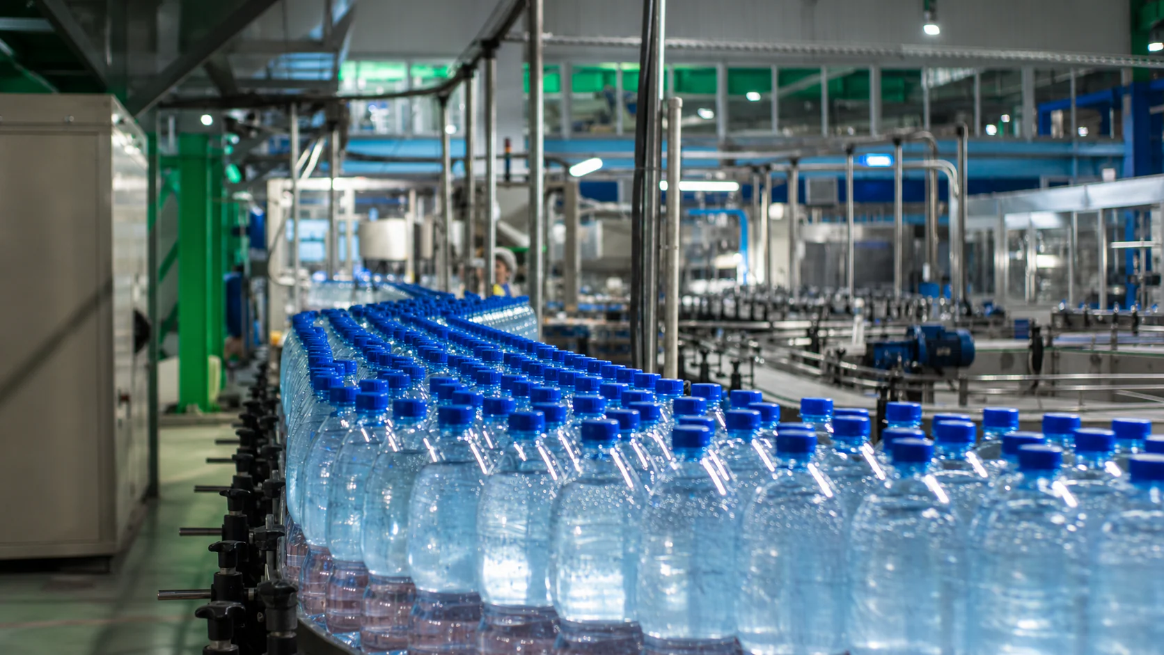 Large-format bottled water moving through a conveyor line in an operating water factory